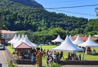 chapiteaux sur un grand terrain, sous lesquels des gens échangent lors du marché de noël de fin d'année de l'ACI BNL